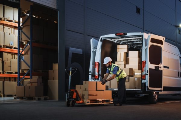 Outside,Of,Logistics,Distributions,Warehouse,Delivery,Van:,Worker,Unloading,Cardboard